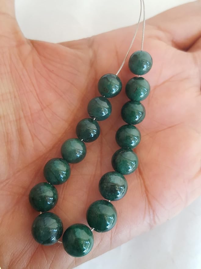 A hand displays a strand of beautiful green emerald natural gemstone beads, highlighting their smooth texture and rondelle design.