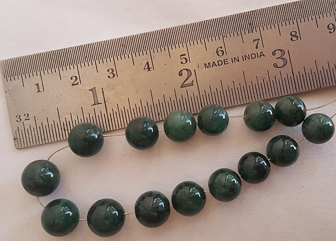 A ruler beside a smooth emerald natural gemstone bead, measuring 8-9mm in diameter.