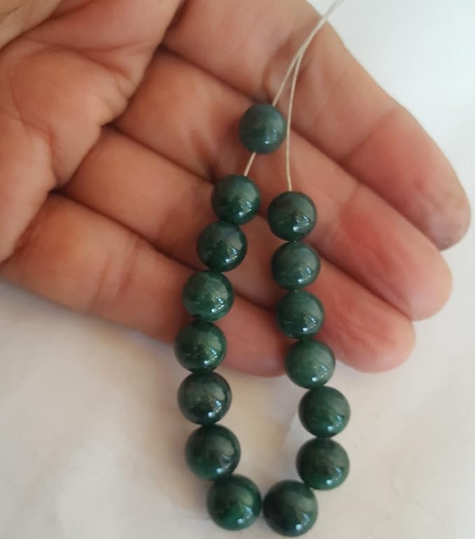 Close-up of a person grasping a strand of emerald gemstone beads, each rondelle measuring 8-9mm in size.