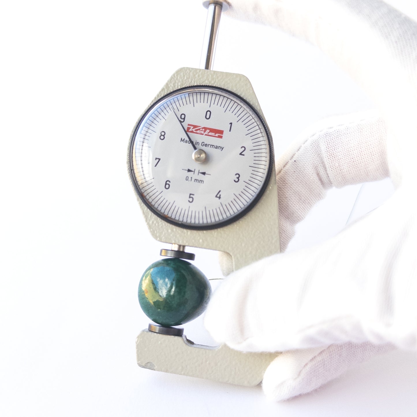 A dial gauge measures the Emerald smooth teardrop 25 × 9mm gemstone.