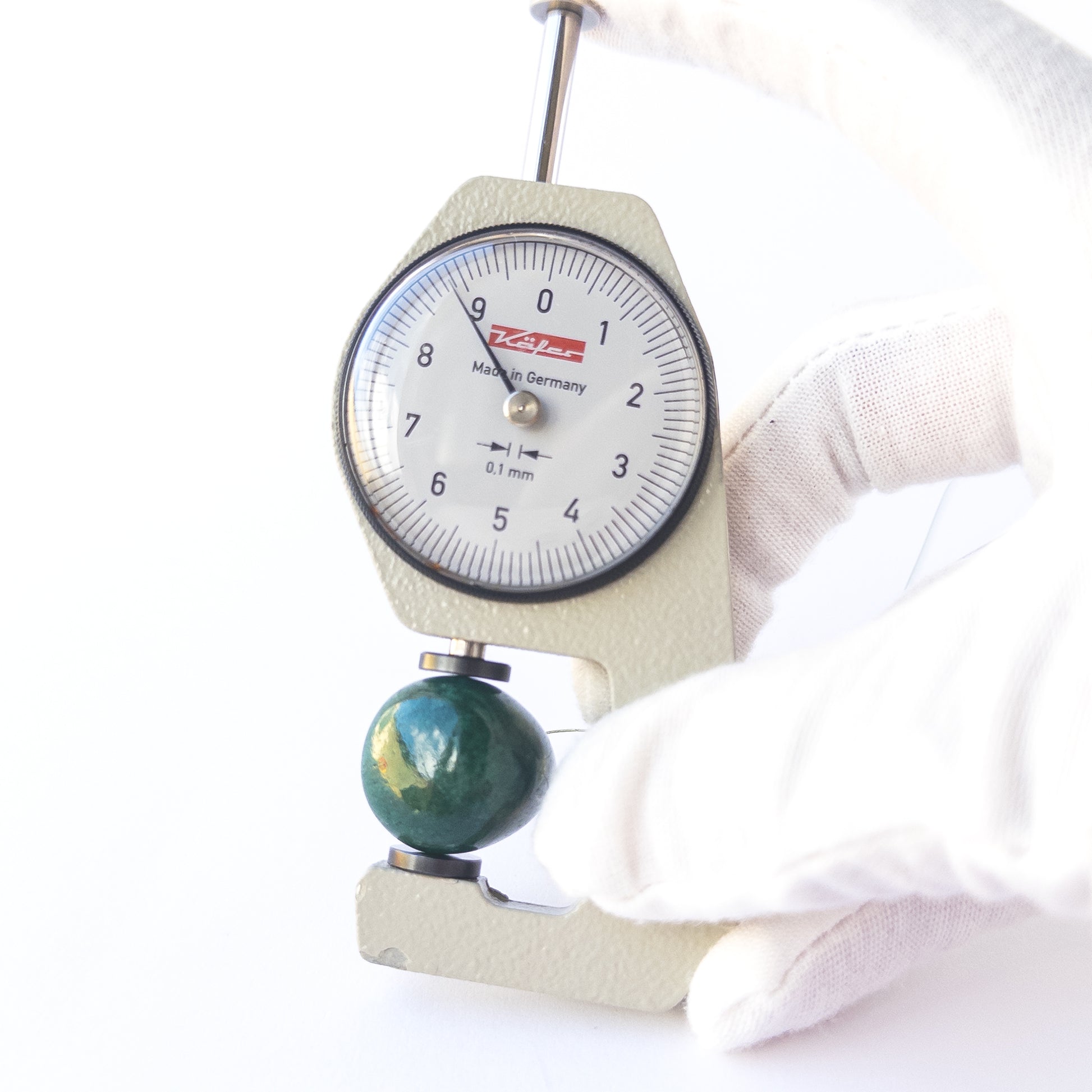 A dial gauge measures the Emerald smooth teardrop 25 × 9mm gemstone.