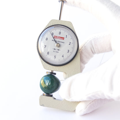 A dial gauge measures the Emerald smooth teardrop 25 × 9mm gemstone.