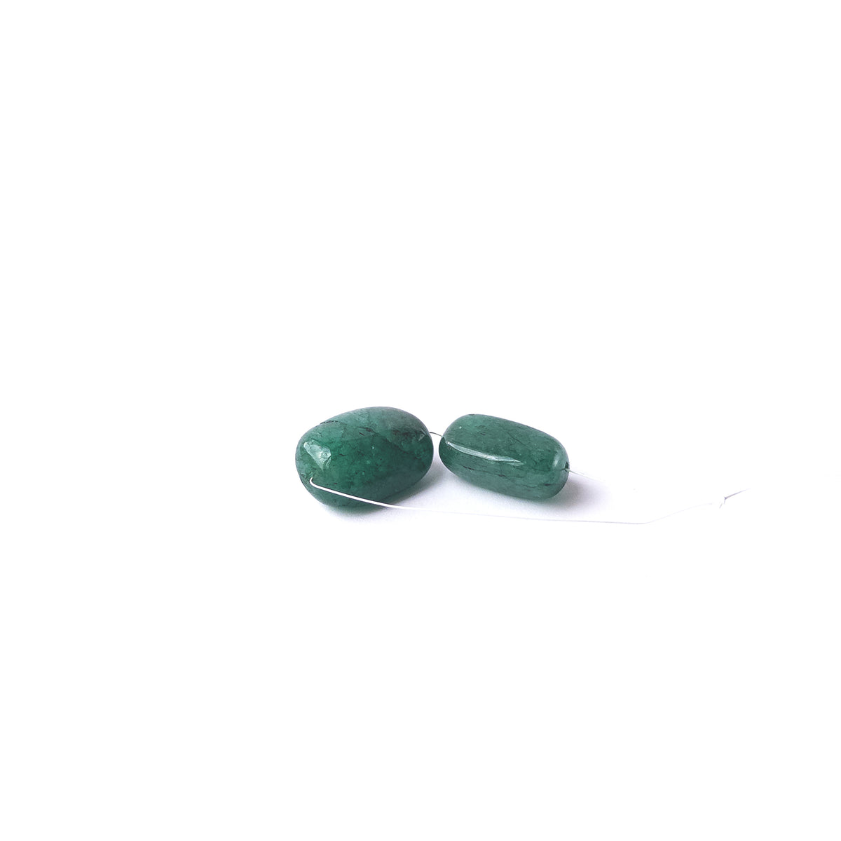 Authentic Emerald tumble beads showcasing polished shine and vibrant green tones.