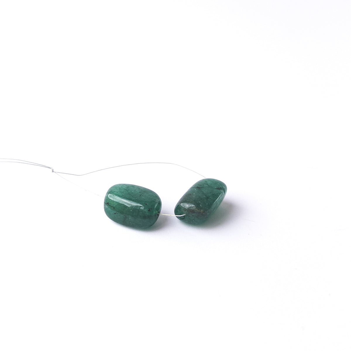 Emerald smooth tumble gemstone beads with rich green colour arranged in a two‑piece set for jewellery making.