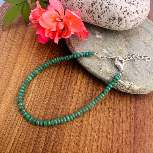 Close-up of gemstone beads featuring Emerald in soft green tones and polished cut. 