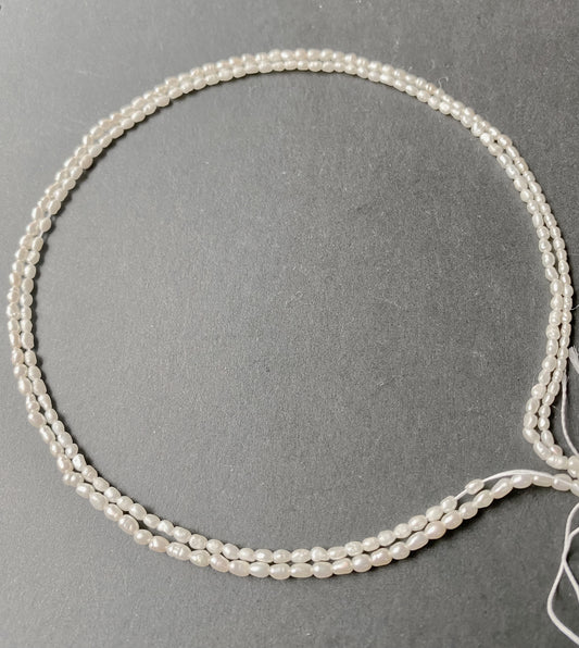 Lustrous Fresh Water Pearls in a fancy smooth rice shape, 2-2.5mm, elegantly strung on a 39cm strand.
