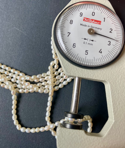 A dial gauge featuring a 2.7mm freshwater rice pearl necklace, showcasing its size and measurement
