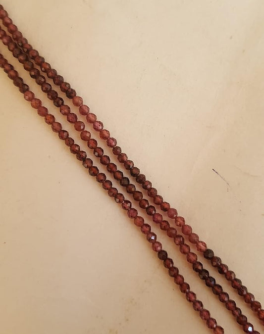 Close-up of a gemstone bead strands highlighting garnet faceted rondelle gemstones.
