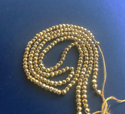 A close-up of Gold Pyrite beads showcasing intricate faceting and polished edges.