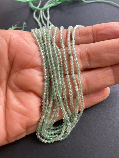  A person holding a faceted rondelle amethyst gemstone strand, showcasing its green facets and elegant design.