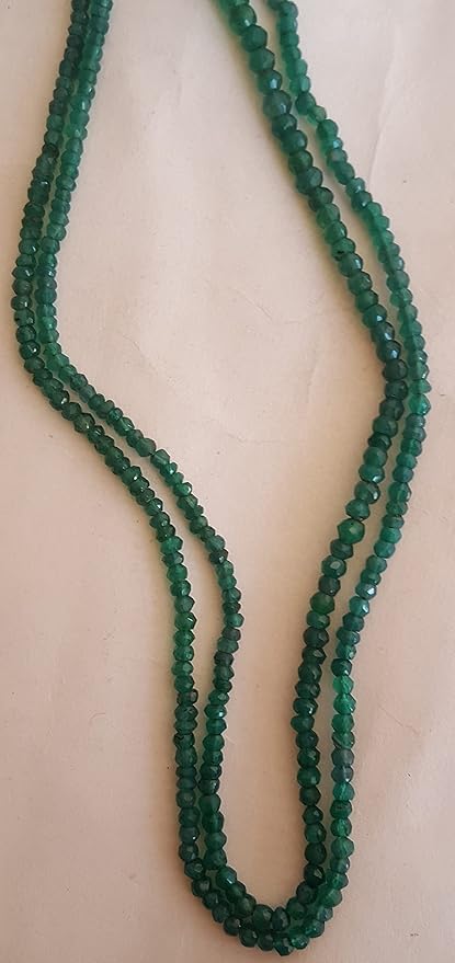 Close-up view of a green onyx beads, emphasising their faceted rondelle shape.