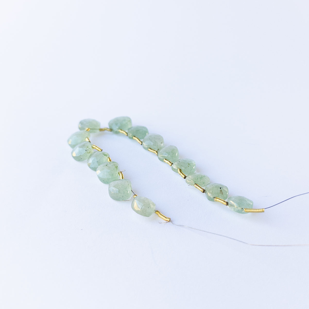 Authentic Green Strawberry Quartz briolette beads showcasing shimmering facets and vibrant colour.
