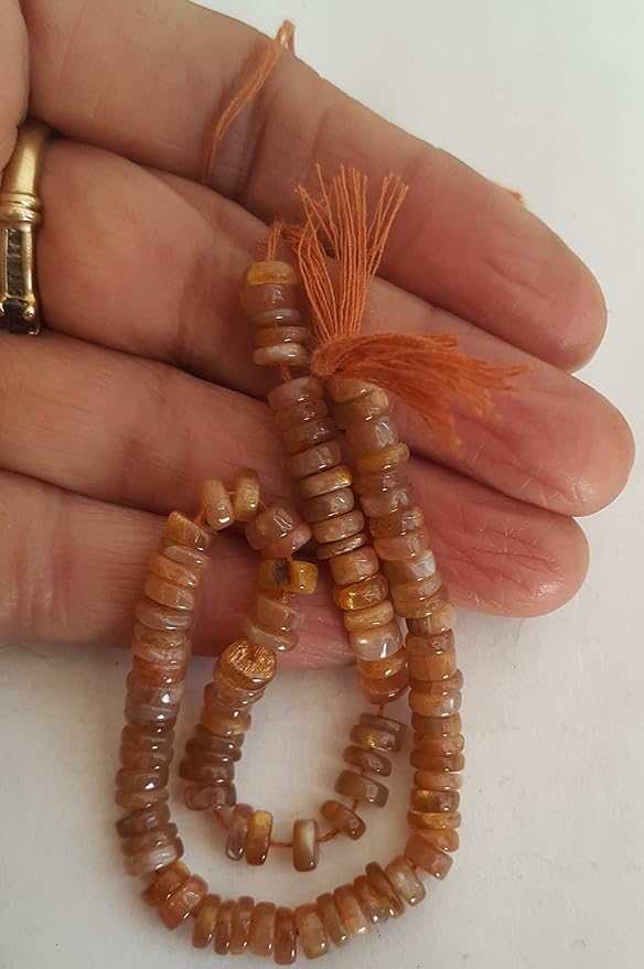A hand displays a strand crafted from Heishi smooth wheel beads, adorned with an array of colourful gemstones.