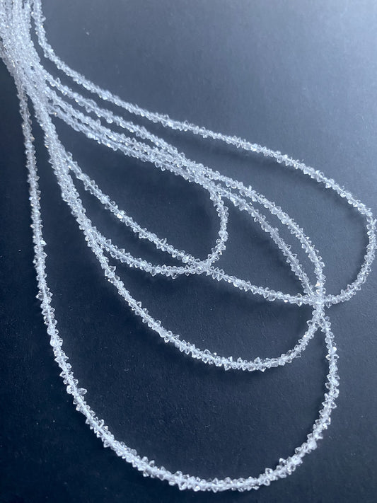  A Herkimer diamond gemstone beads displayed on a table, highlighting its unique shape and brilliant clarity.