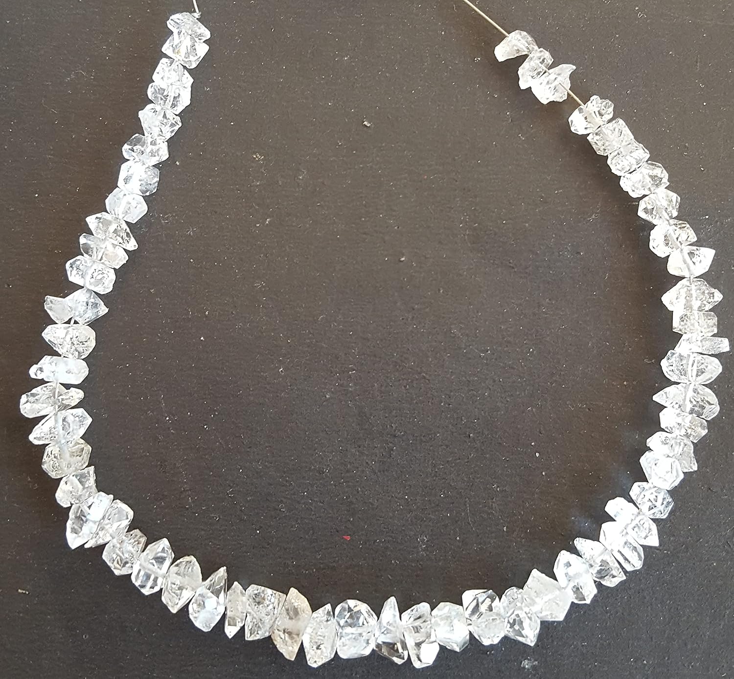 A strand crafted from rough Herkimer diamond natural gemstone, featured on a dark background.