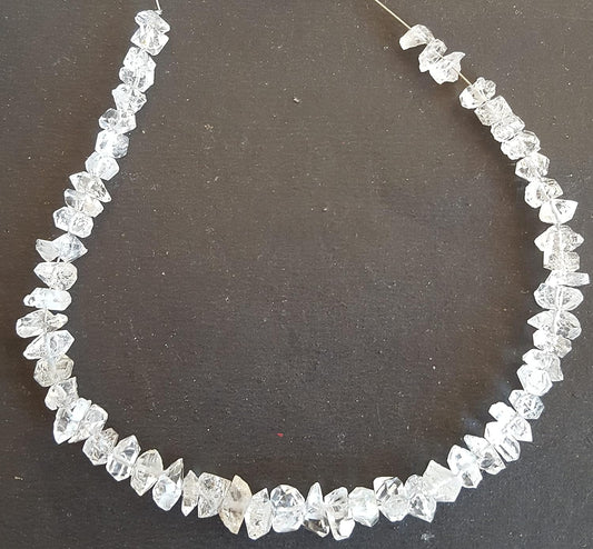 A strand crafted from rough Herkimer diamond natural gemstone, featured on a dark background.