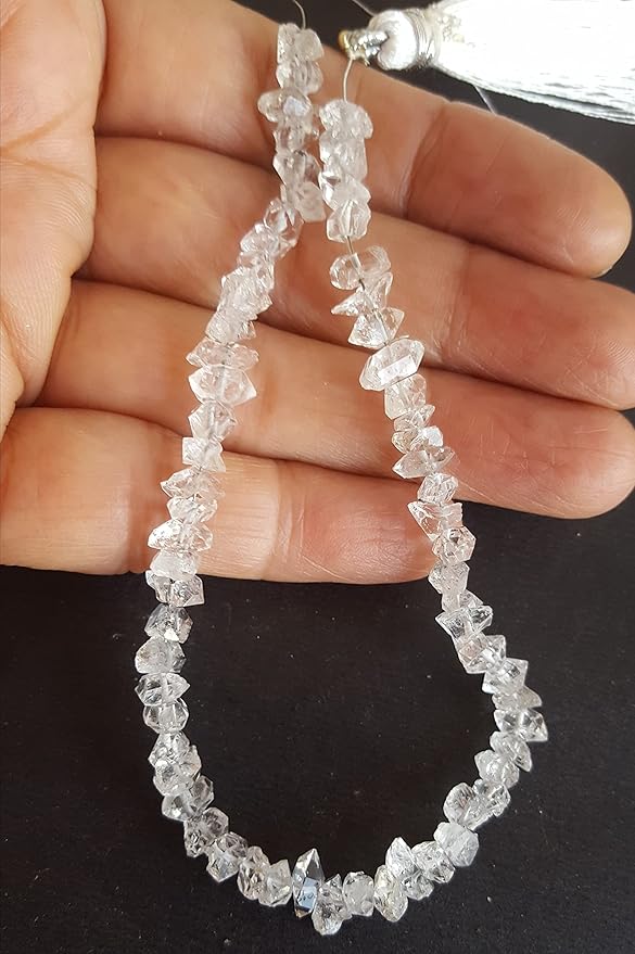 Stylish strand of Herkimer Diamond rough centre-drilled beads with a silver tassel, place on the fingers of a person's hand