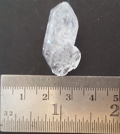 A Herkimer diamond gemstone, undrilled and rough, positioned on a table with a ruler.