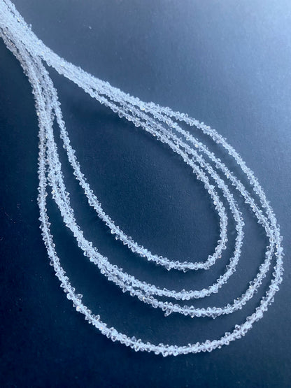  A Herkimer diamond stone beads on a table, featuring its striking clarity, capturing light beautifully.