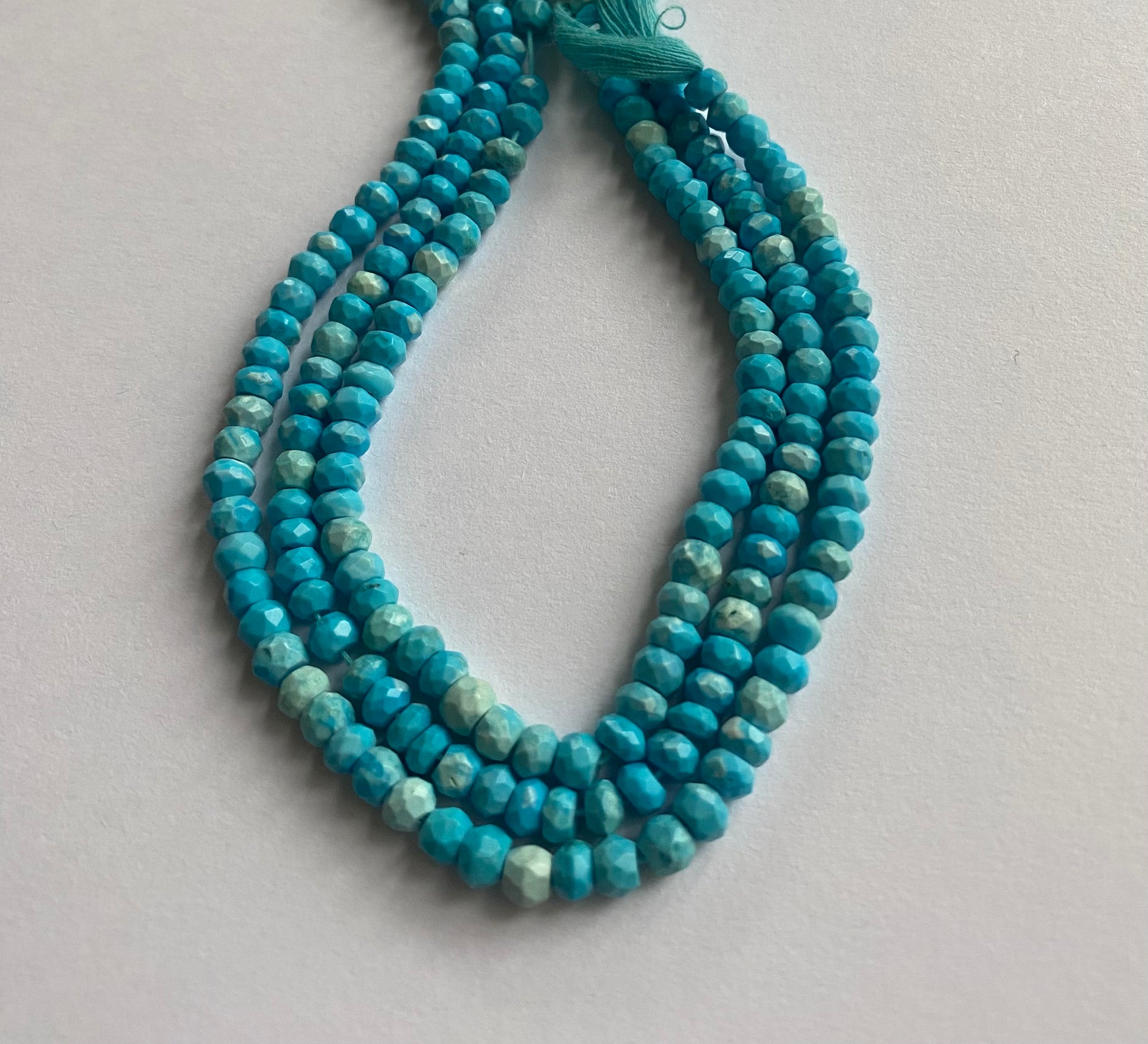 Strands of Howlite Turquoise beads, faceted rondelle style, measuring 4.5-5.0mm in size.