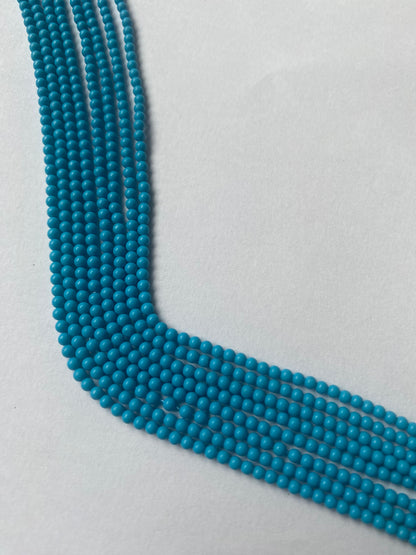 Strands of Smooth Round Howlite Turquoise beads, ranging 2.3mm  in size, showcasing their vibrant colour and shine.