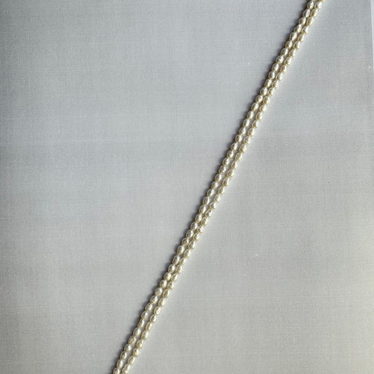 Freshwater pearls arranged in a strand, displaying their uniform shape and natural glow.