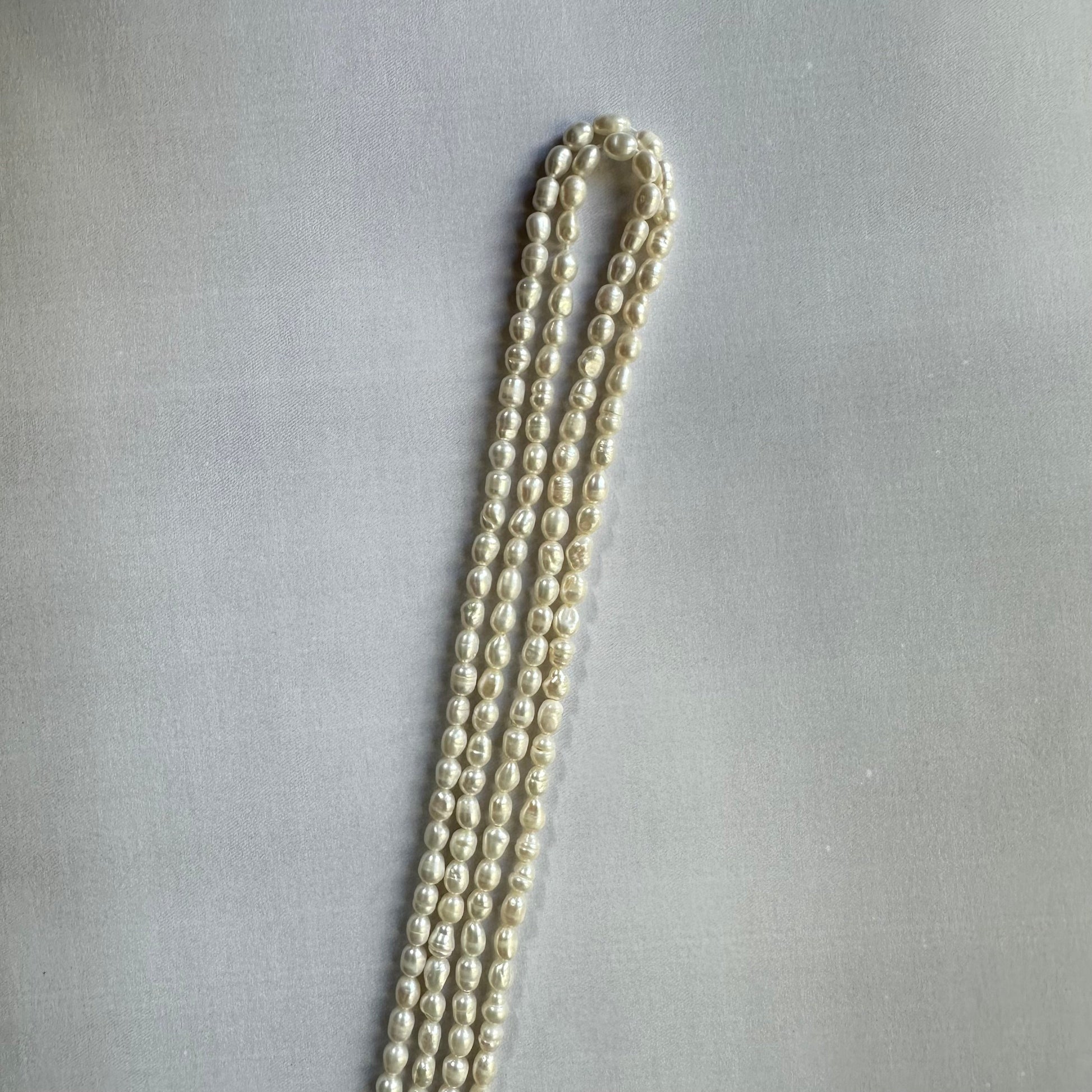 Loose freshwater pearl smooth rice beads spread out, revealing their consistent sizing and high-quality craftsmanship.