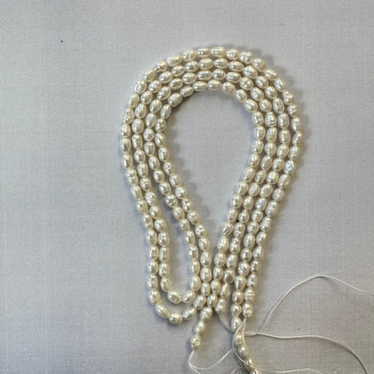 Uncut freshwater pearl strands coiled together, emphasising their soft hues and versatility in jewellery designs.