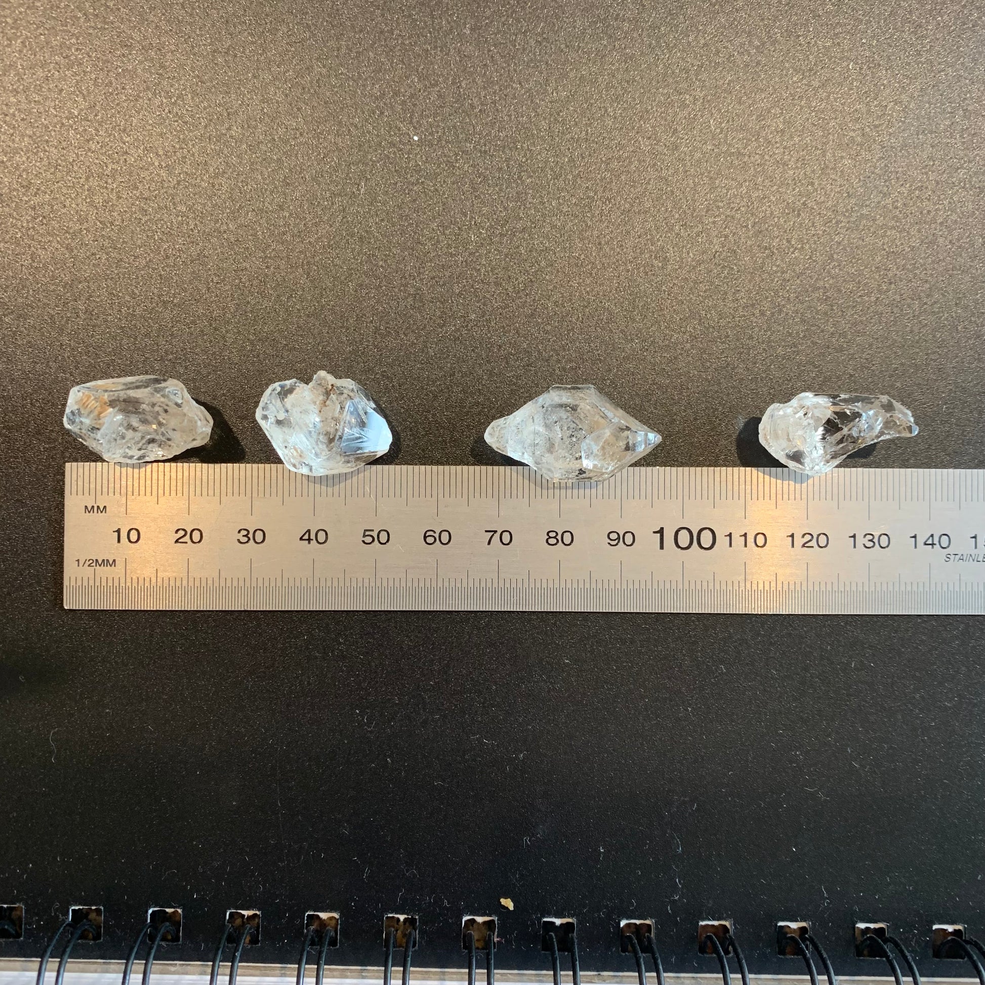 A ruler measures the Herkimer Diamond rough undrilled 21mm gemstone, ensuring precise sizing.