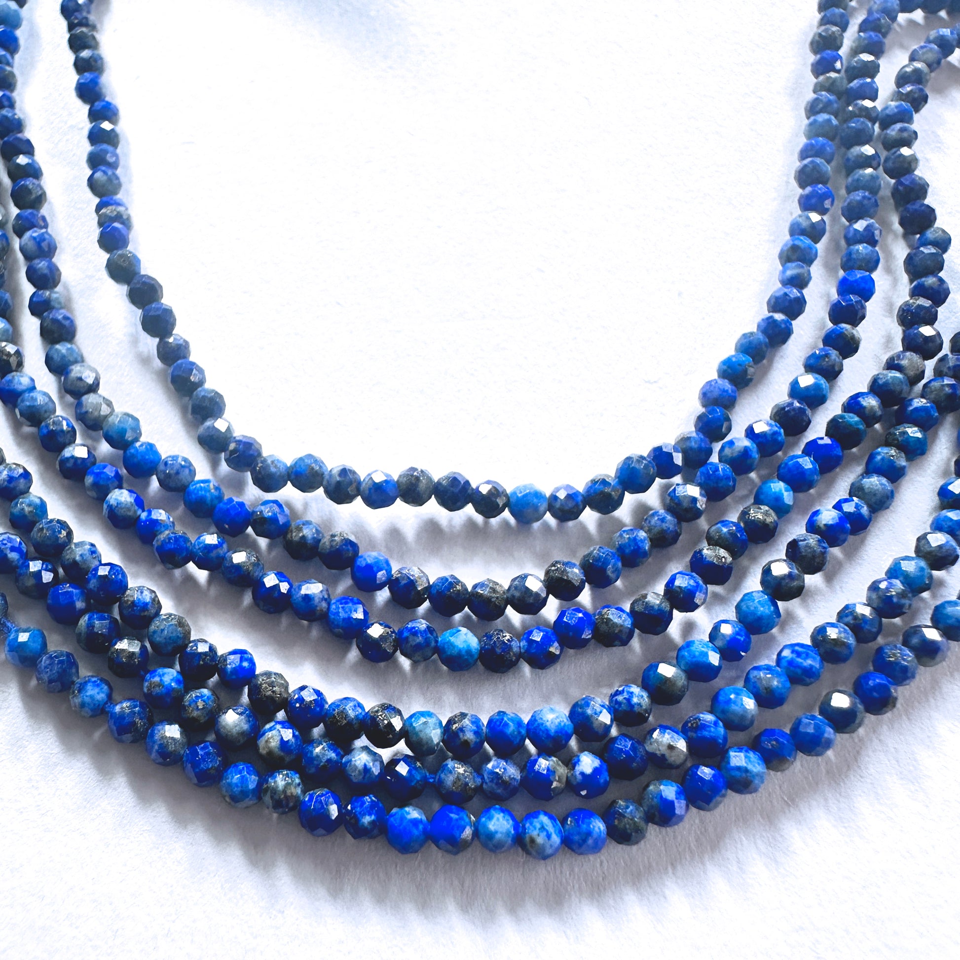 Lapis Lazuli gemstone beads in faceted rondelle shape reflect light with subtle brilliance