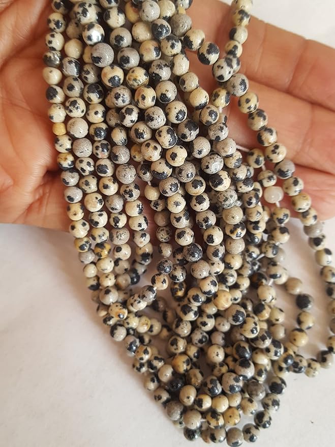 A decorative strand of 4mm to 4.5mm beads, each smooth and round, adorned with unique black and cream spots.