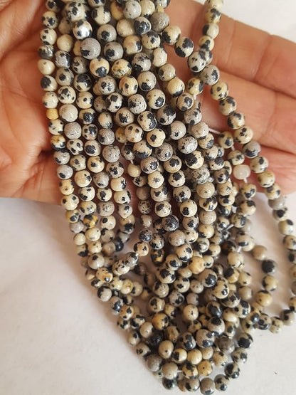 A decorative strand of 4mm to 4.5mm beads, each smooth and round, adorned with unique black and cream spots.