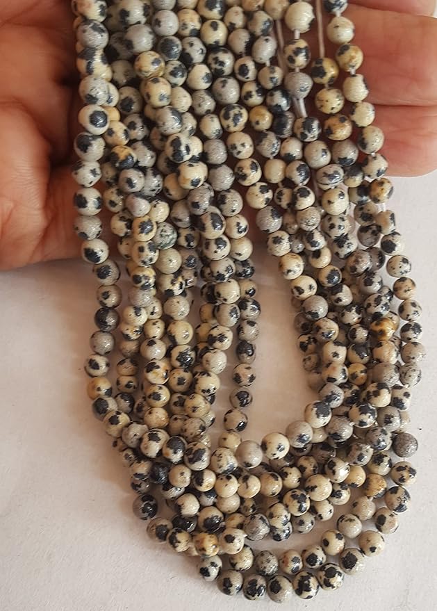 Close-up of a bead strand with 4mm to 4.5mm smooth round beads, showcasing a striking black and white spotted design.
