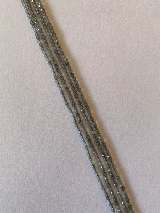 Strands of Faceted Rondelle Labradorite beads, ranging 2.5-2.7mm in size, showcasing their vibrant colour and shine.