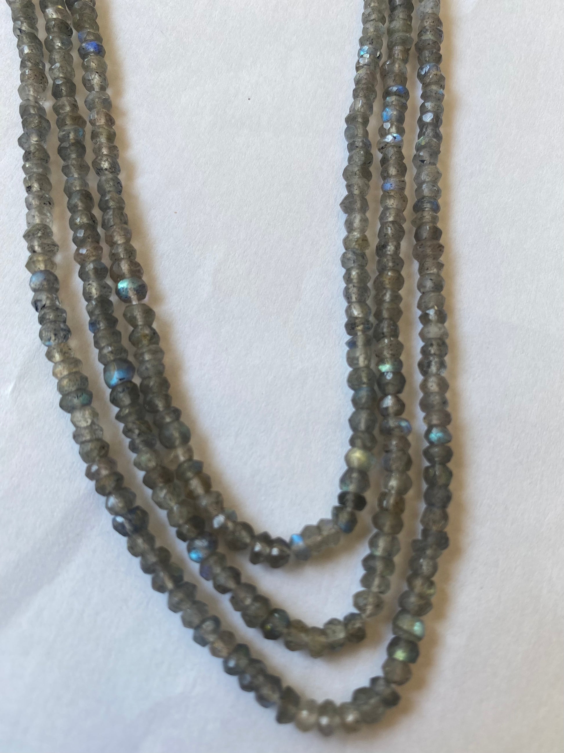 A close-up of a multiple strands  featuring labradorite faceted rondelle beads, measuring 3.5mm in size.