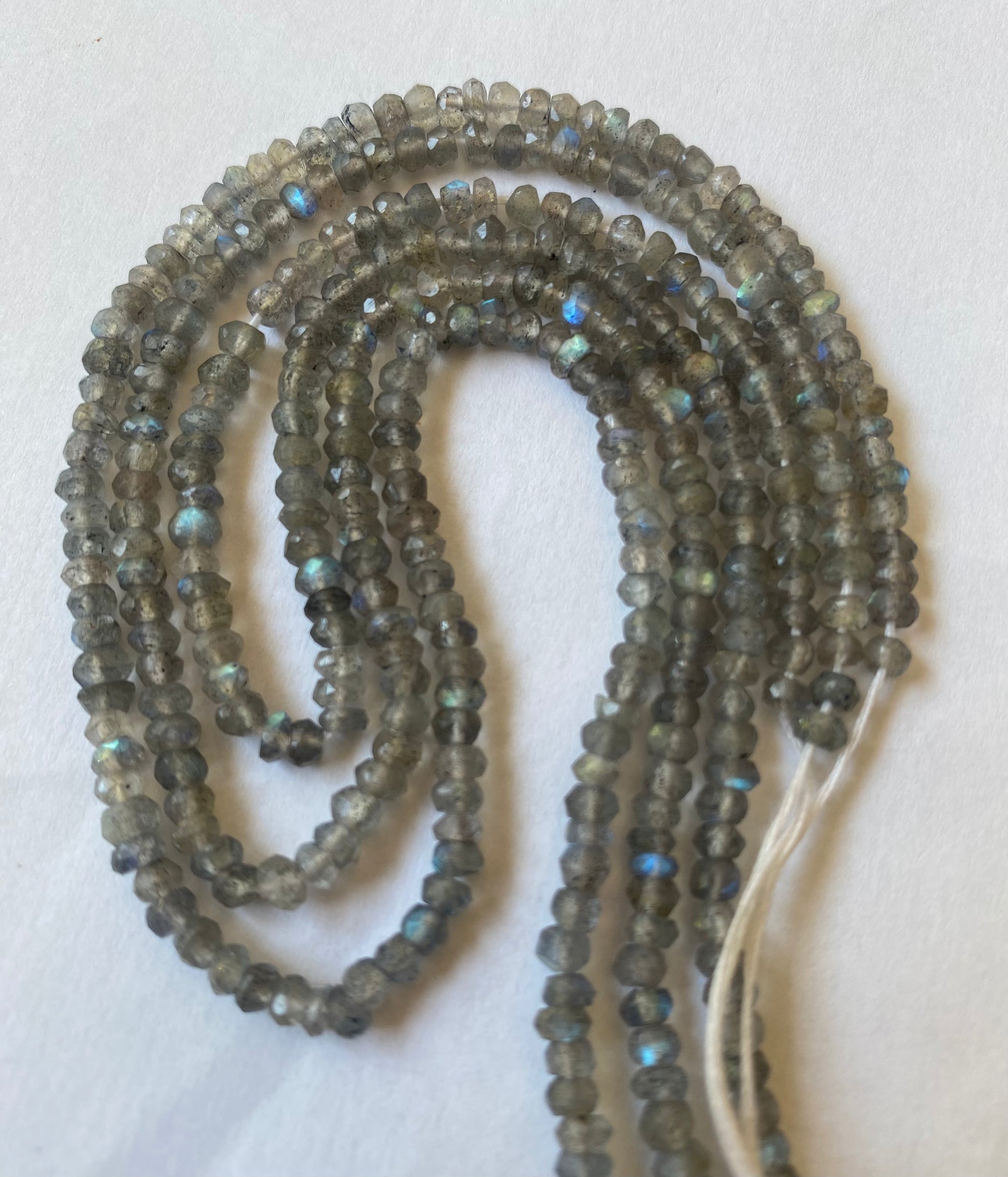 A close-up of a multiple strands  featuring Labradorite faceted rondelle beads, measuring 3.5mm in size.