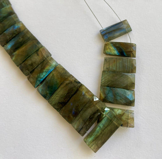 Labradorite faceted rectangle beads with blue-green flash, arranged in a 20-piece set.