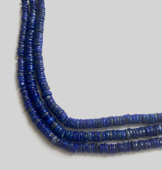 Lapis Lazuli smooth wheel beads with rich blue hues and gold flecks, arranged on a 20cm strand.