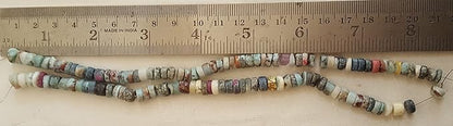 A ruler beside a cluster of Larimar gemstone beads, measuring 6mm to 7mm in size.
