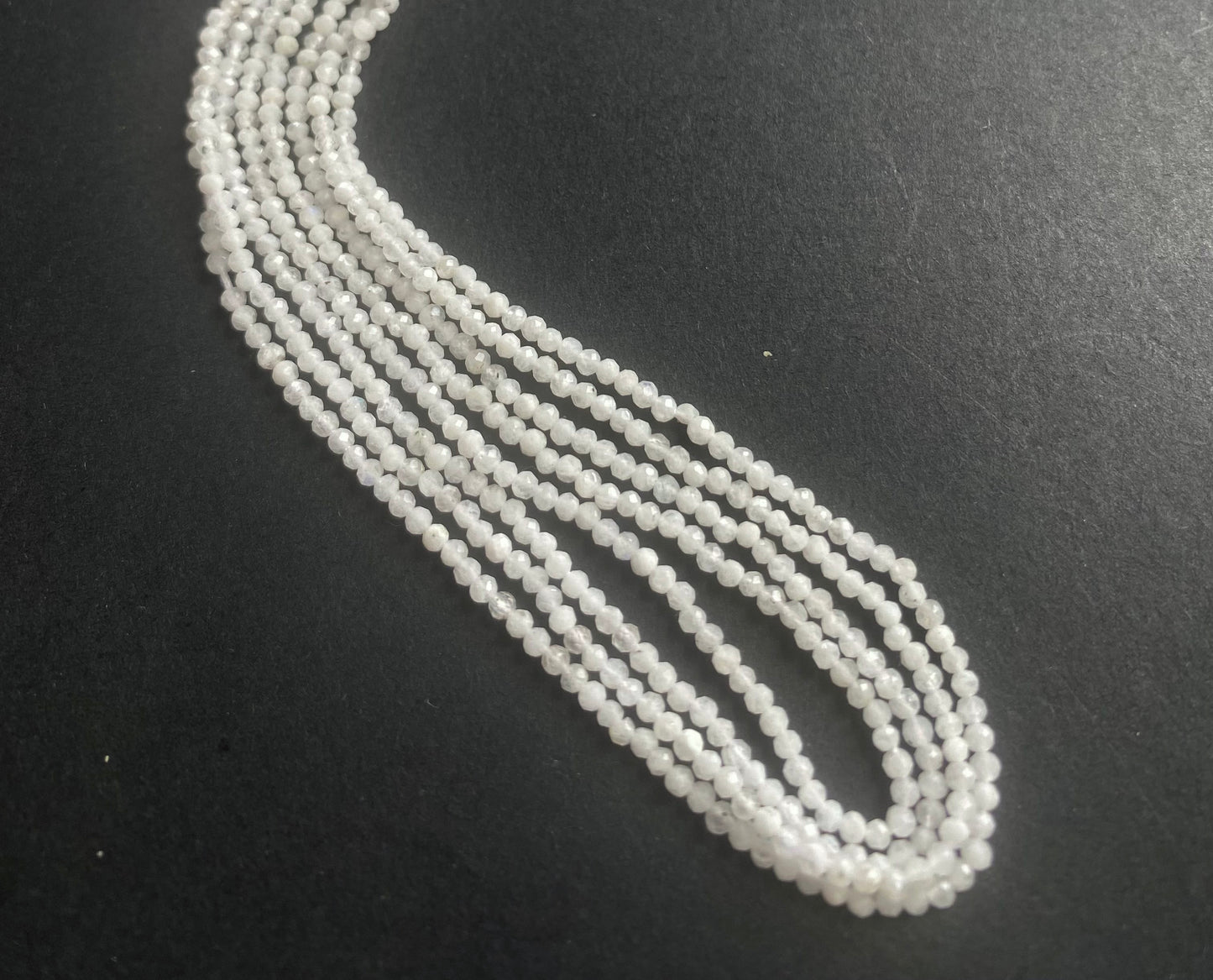 Long strands of white Moonstone faceted rondelle beads, showcasing their natural beauty and unique colours.