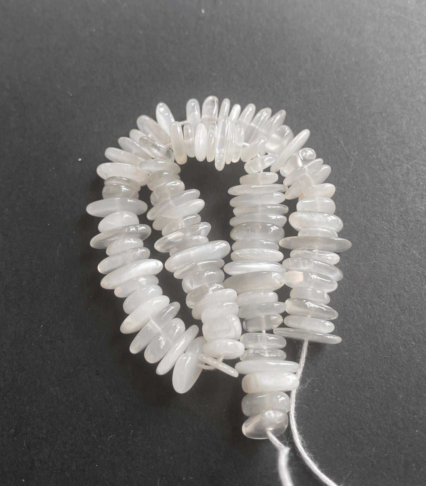 An elegant strand of Moonstone smooth chips, highlighting their luminous, natural sheen.