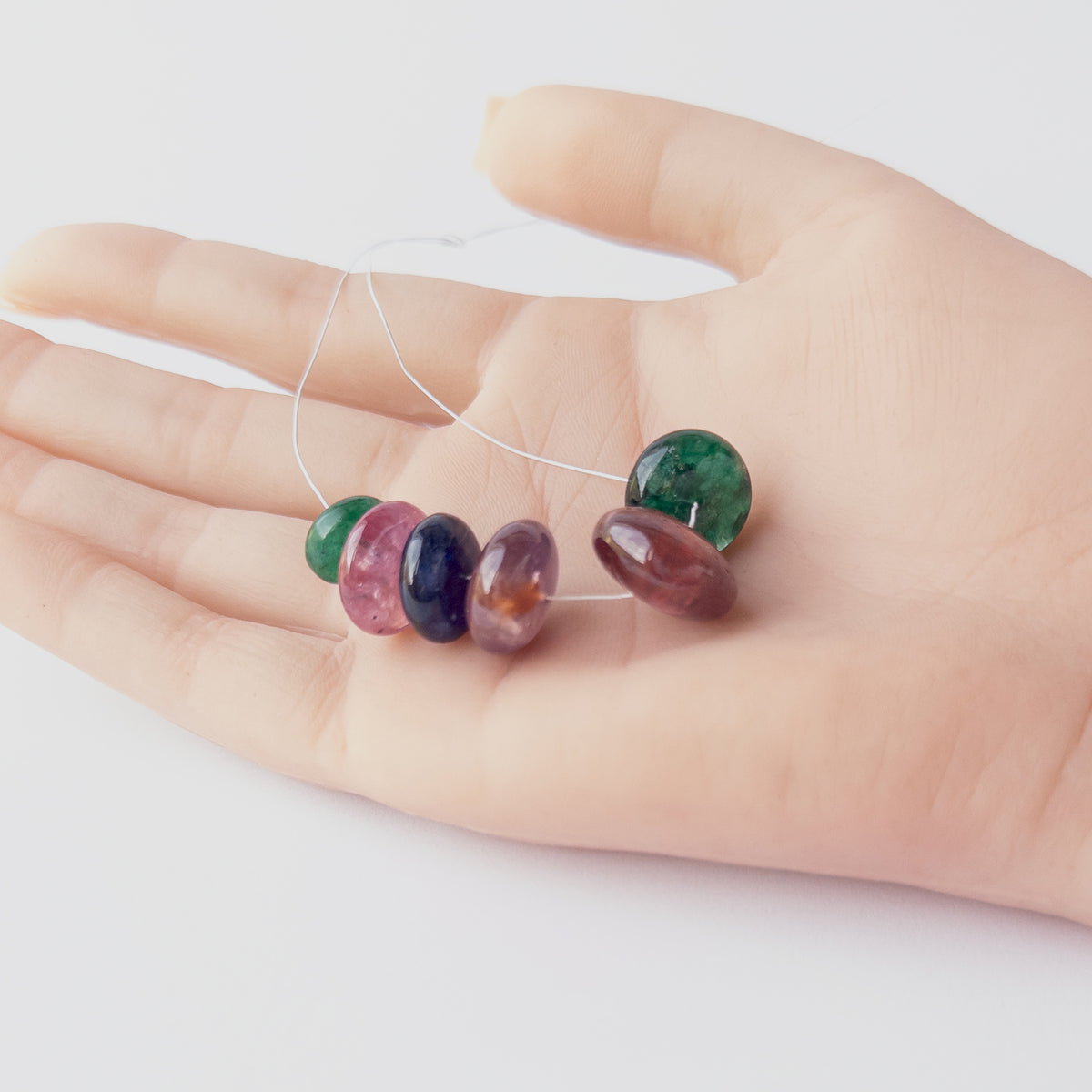High‑quality Emerald, Ruby and Blue Sapphire stone beads arranged neatly for handmade jewellery components.