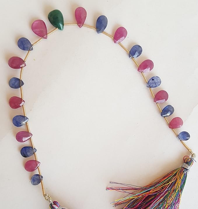 A colourful strand made of faceted rondelle beads in ruby, blue sapphire, and emerald against a white backdrop.