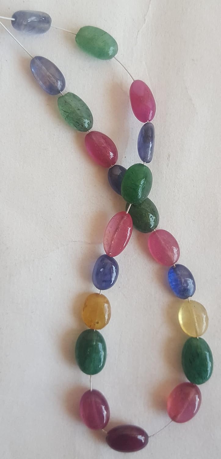 A colourful strand made of faceted rondelle beads in ruby, blue sapphire, yellow sapphire, and emerald against a white backdrop.