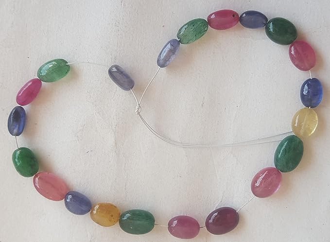  A vibrant multi-coloured strand featuring ruby, blue sapphire, yellow sapphire, and emerald beads on a white background.