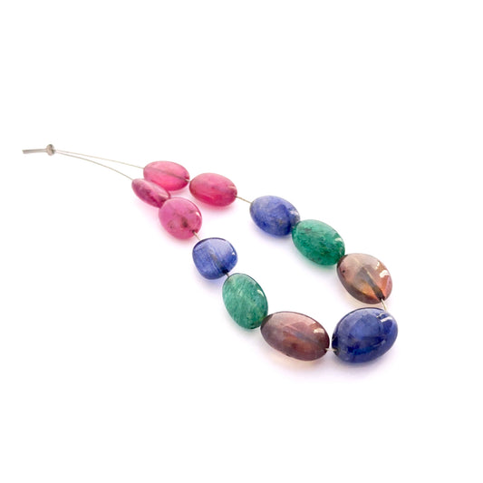 Multi stone smooth oval beads 7–9mm featuring ruby, yellow sapphire, blue sapphire and emerald, 11 pieces, 59 carats.
