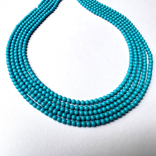 Turquoise bead on a white background
