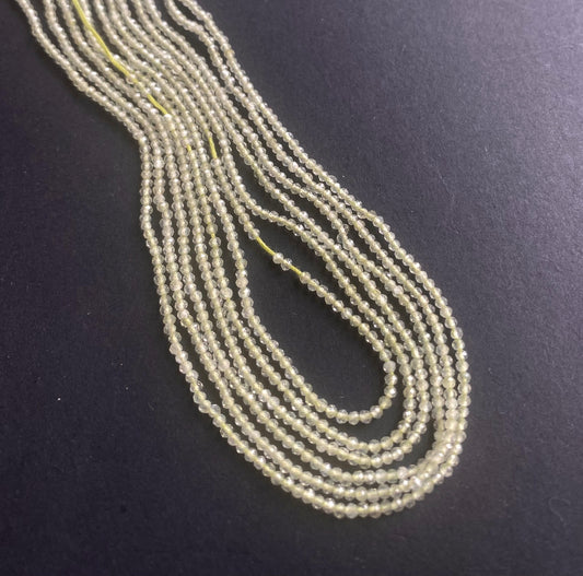 A grouping of 1.9mm faceted Prehnite beads, highlighting their beautiful green hue.