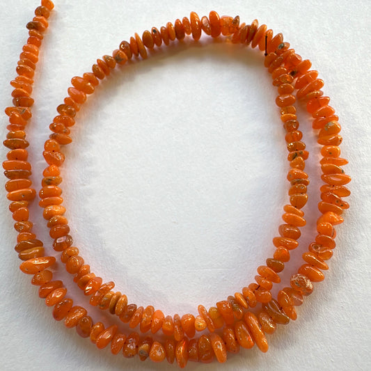 Close-up of dyed opal beads showing smooth chip cuts and subtle shine.