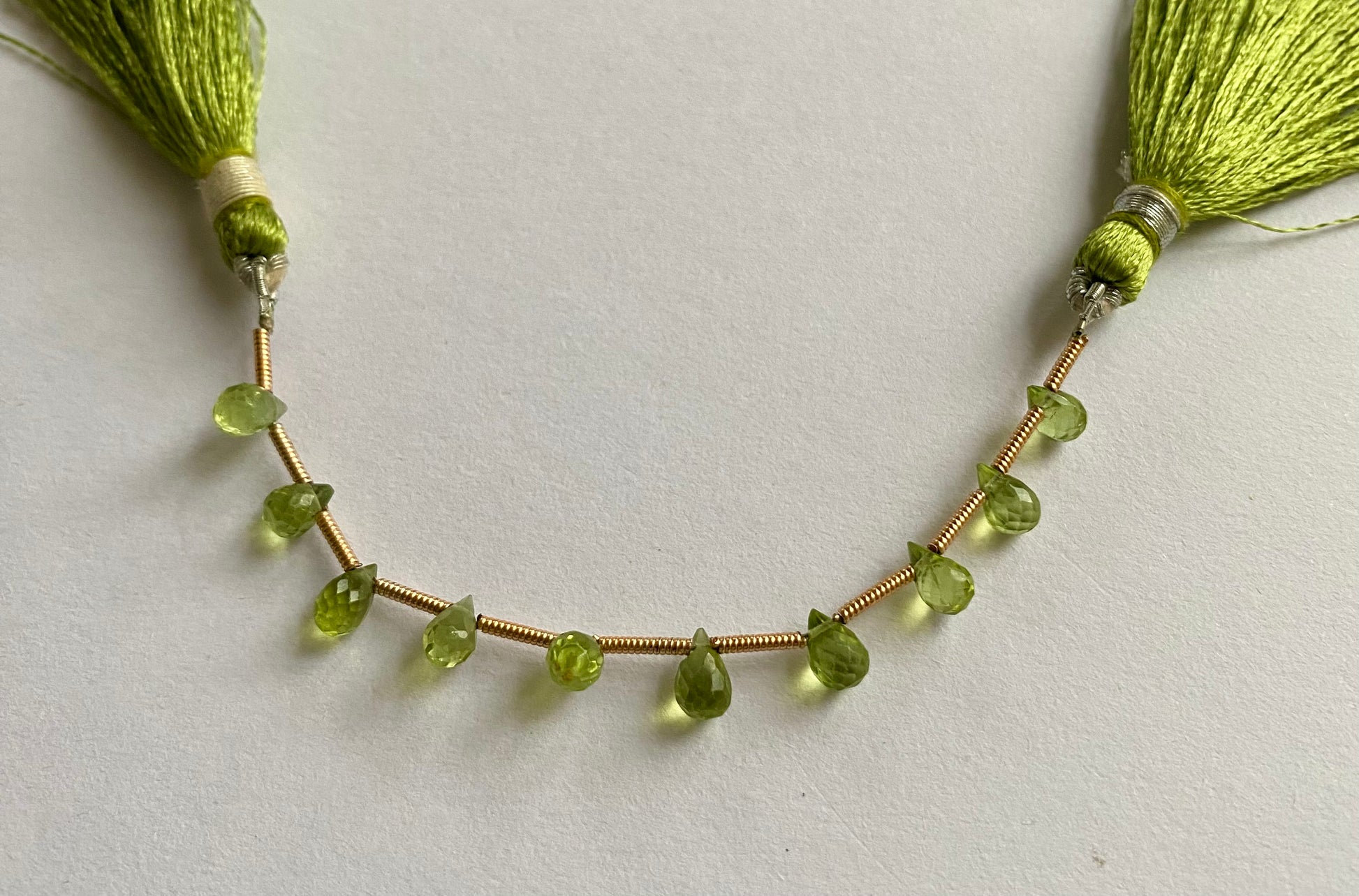 Elegant strand adorned with faceted teardrop peridot stones, showcasing a rich green colour.